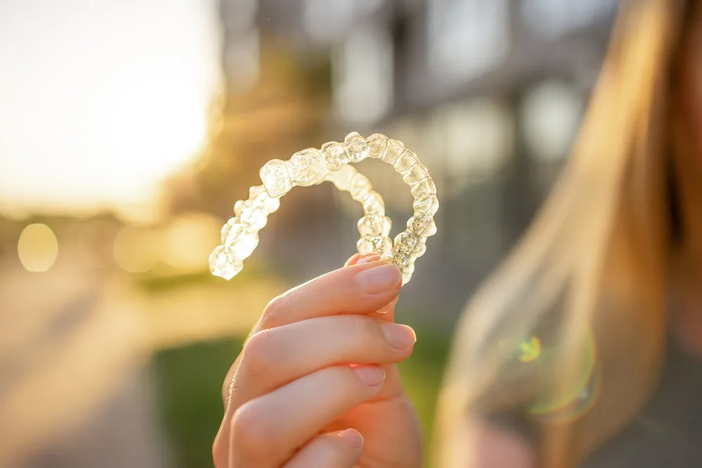 Clear aligner tray held up to the light
